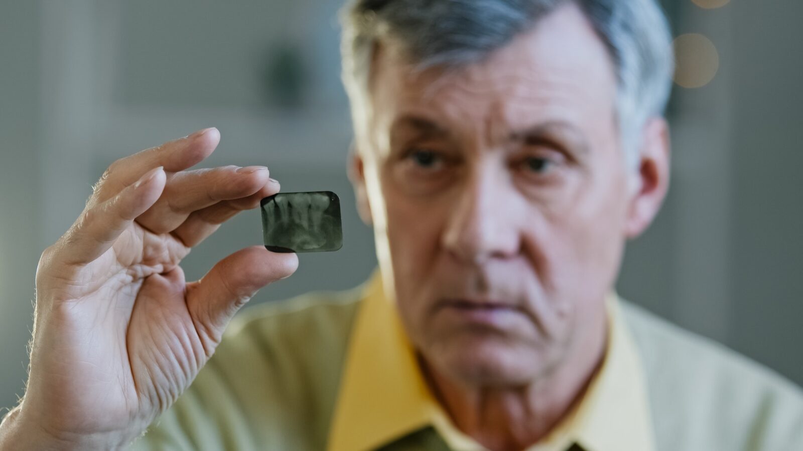 close-up-sad-caucasian-old-senior-mature-man-indoor-patient-with-toothy-ache-pain-sick-male-holding-1600x900