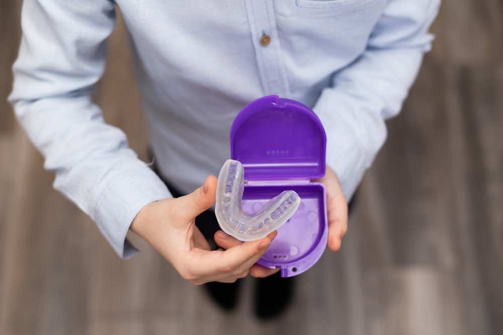 girl-holding-aligner-in-a-purple-box