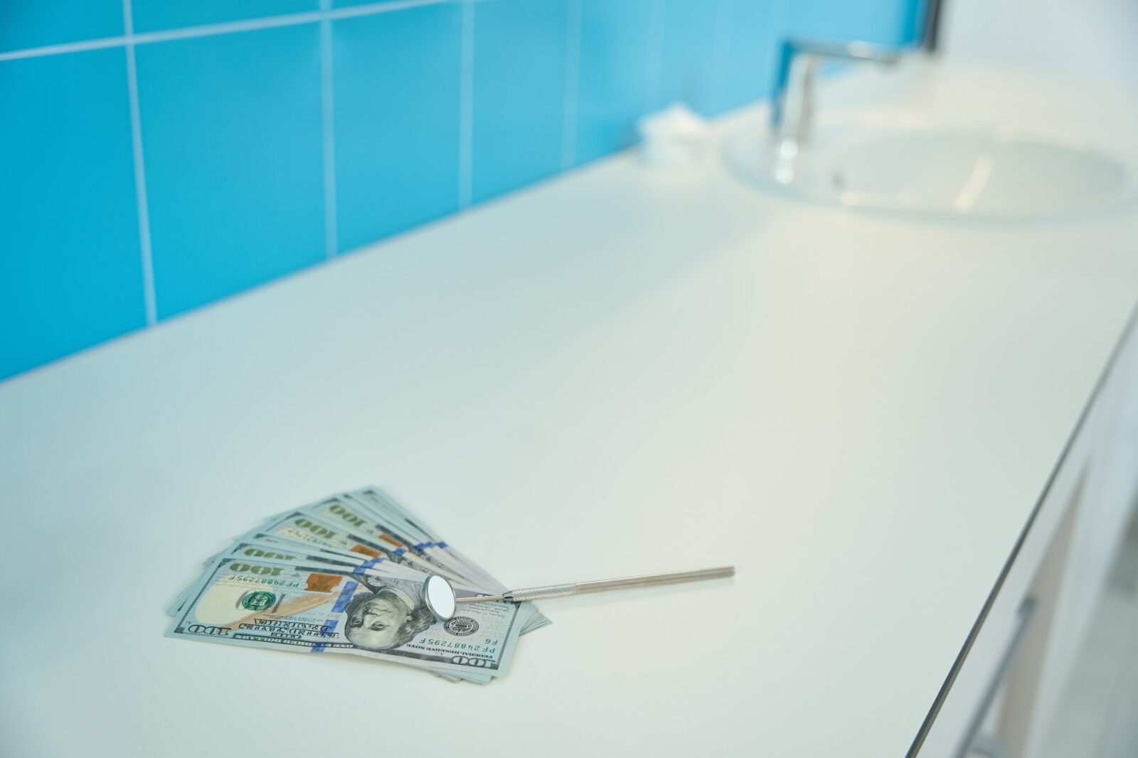 Stomatological oral mirror lies on table with money dentist office