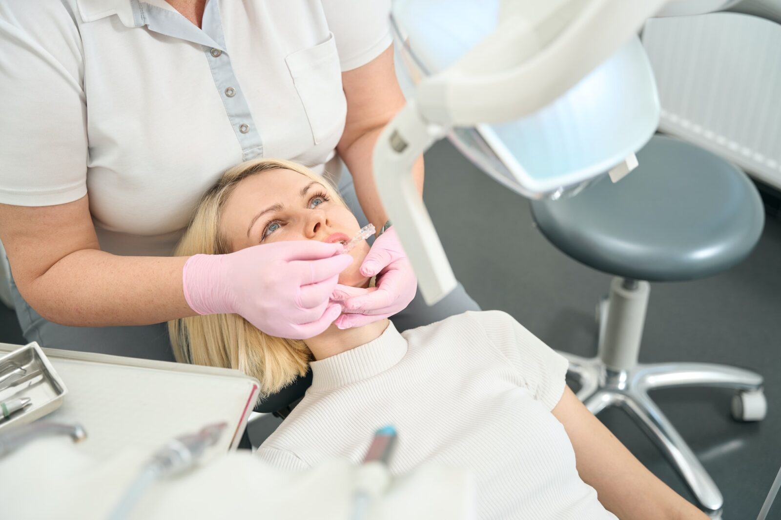 woman-dentist-putting-aligners-on-her-teeth-1600x1066