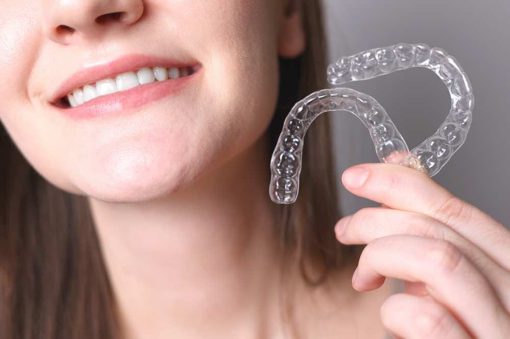 woman-holding-two-clear-aligners